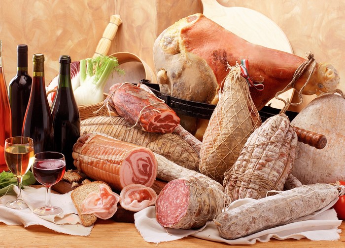 Assortment of cured meats and wine bottles