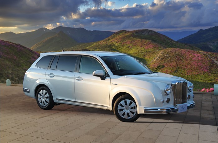 White Mitsuoka Ryugi Hybrid Wagon in a Mountainous Landscape
