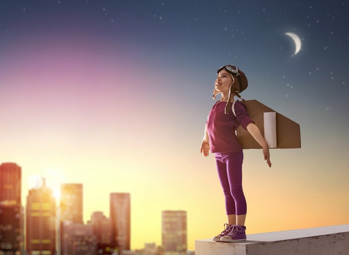 Girl with cardboard jetpack on rooftop at night