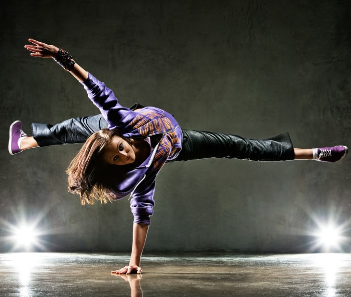 Breakdancer in mid-air pose with legs extended