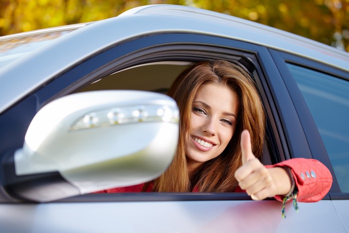 Woman in car giving thumbs up