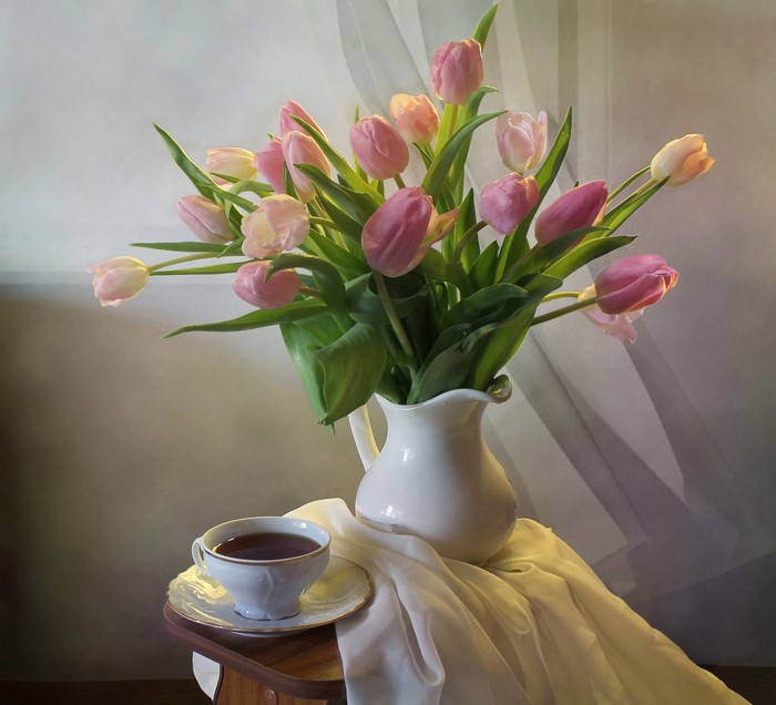 Still-life of pink tulips in a vase with a cup of tea
