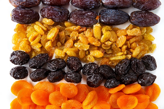Dried fruits: raisins, prunes, and apricots on white background