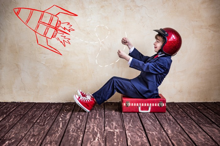 Boy in Suit and Helmet Pretending to Fly a Rocket