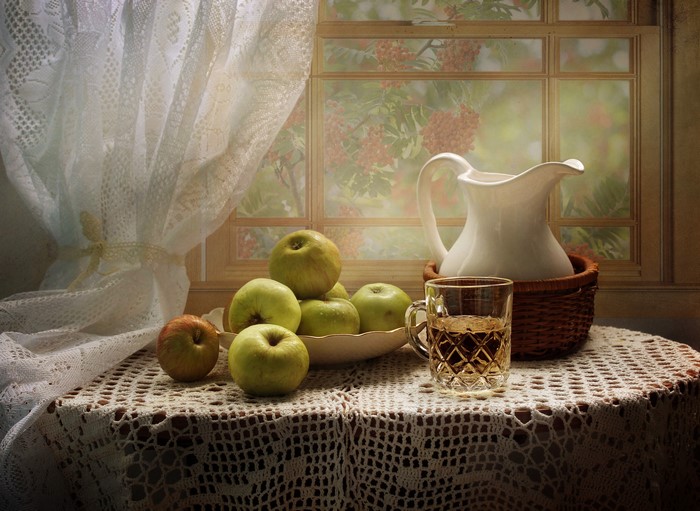 Still life with apples, jug, and glass on a table
