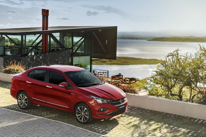 Red Fiat Cronos Precision parked near a modern building by a lake