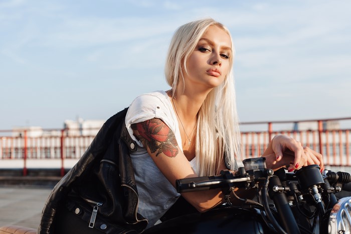 Blonde woman with tattoo on motorcycle
