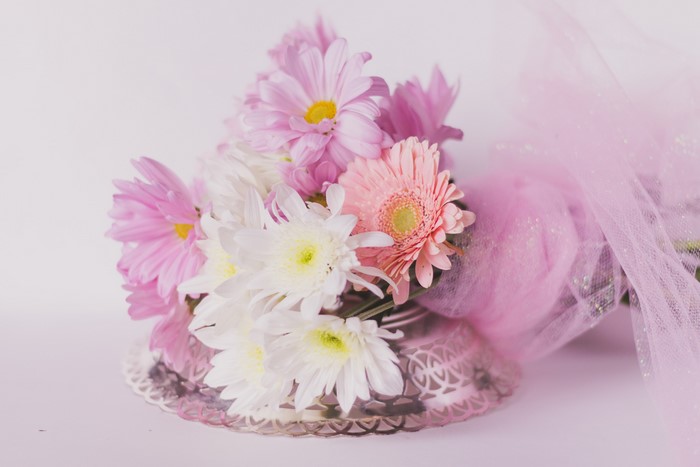 Pink and white flowers in a silver vase with pink tulle