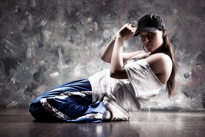 Young woman in baseball cap dancing