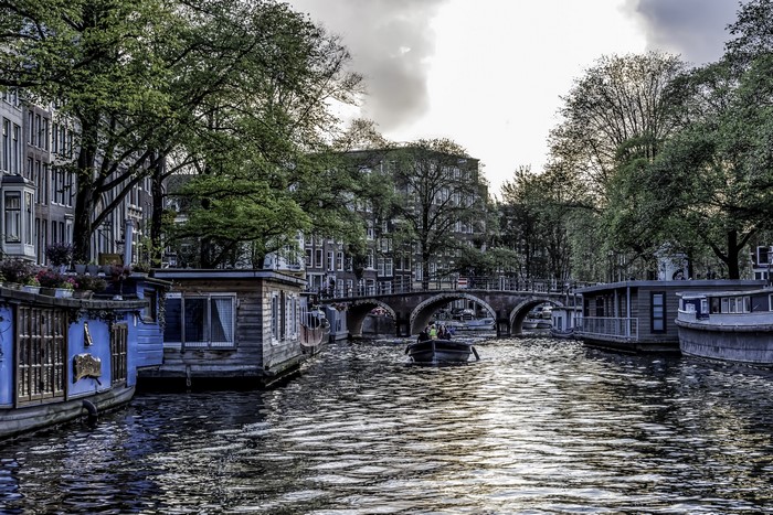 Amsterdam canal with houseboats and bridge