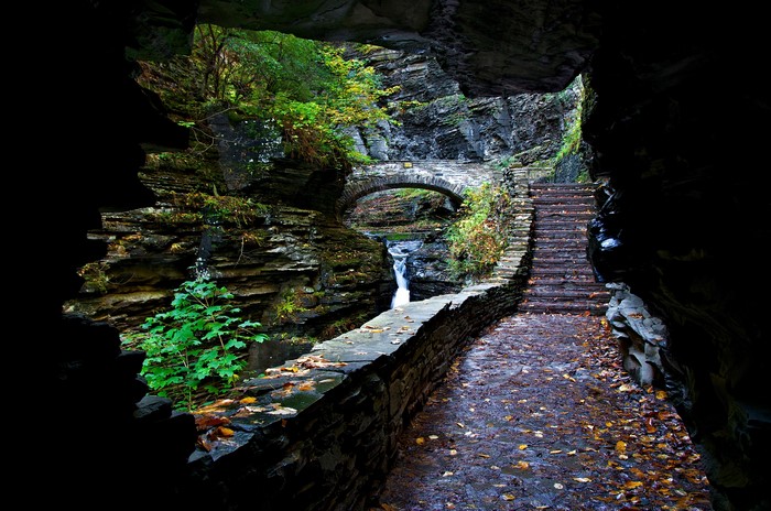 Stone bridge and stairs in a rocky gorge with a waterfall