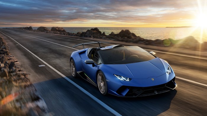 Blue Lamborghini Huracan Spyder driving on coastal road