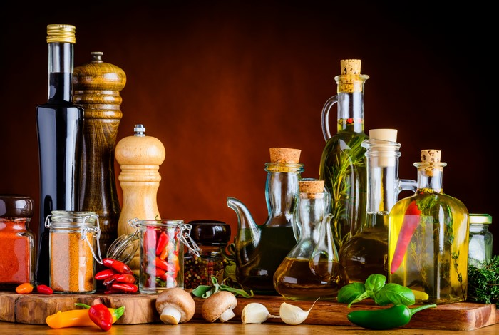 Spices, Peppers, Mushrooms, and Oils on a Wooden Board