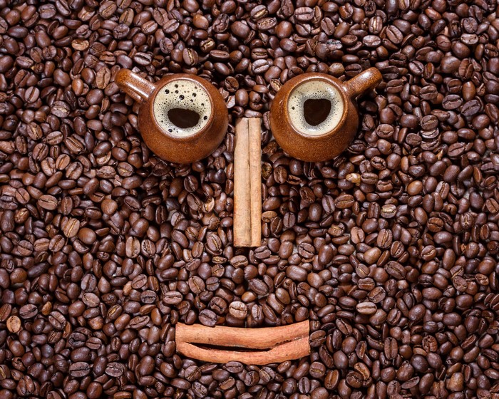 Coffee beans with cups and cinnamon sticks