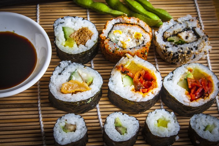 Assortment of sushi rolls with soy sauce and edamame