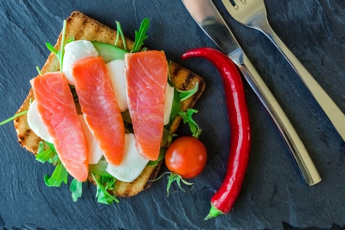 Open-faced sandwich with salmon, mozzarella, and arugula