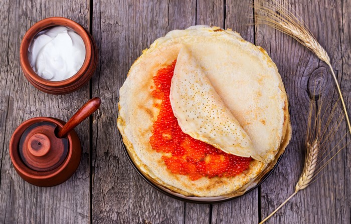 Pancakes with Caviar and Sour Cream on Wood