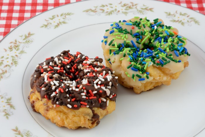 Two donuts with sprinkles on a plate