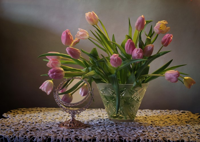 Still-life of pink tulips in a vase with a mirror
