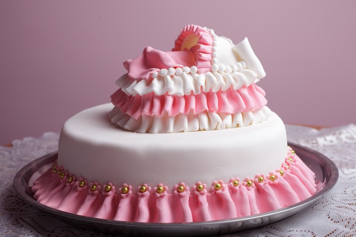 Pink and white ruffled baby carriage cake