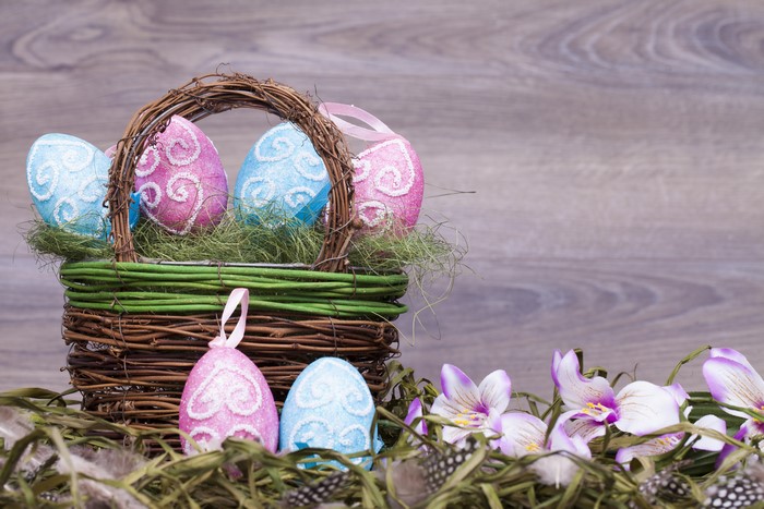 Easter eggs in a wicker basket with flowers