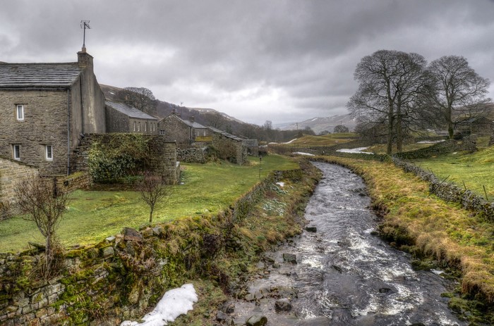 Stone houses by a river in Thwaite, England