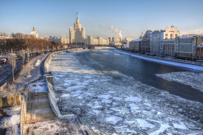 Moscow River in winter with ice floes and buildings