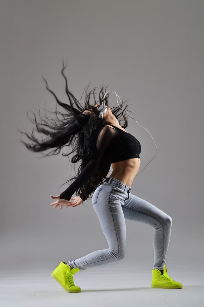 Woman with long hair dancing with headphones