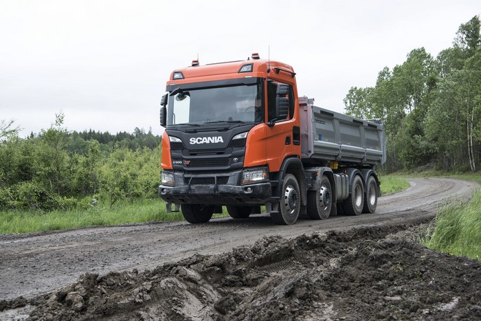 Scania dump truck driving on a dirt road