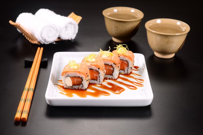 Salmon Sushi Rolls with Tea and Chopsticks