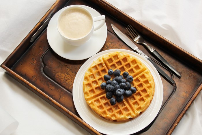 Waffles with blueberries and coffee on a tray
