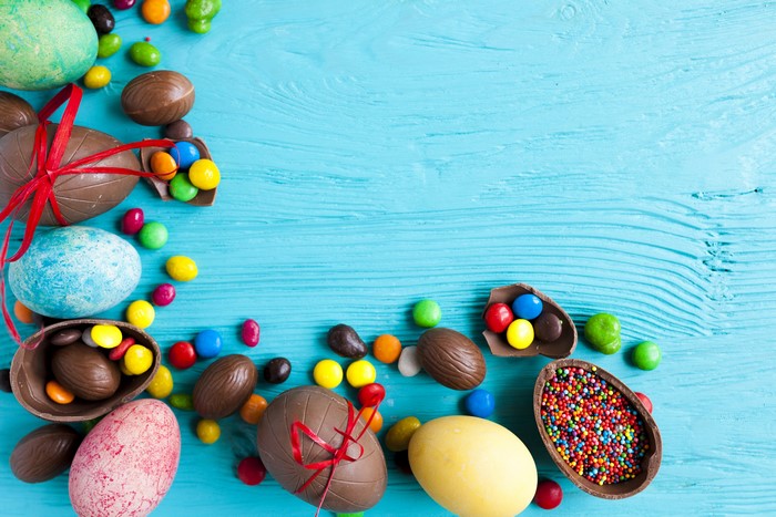 Easter chocolate eggs and candies on a blue wooden background