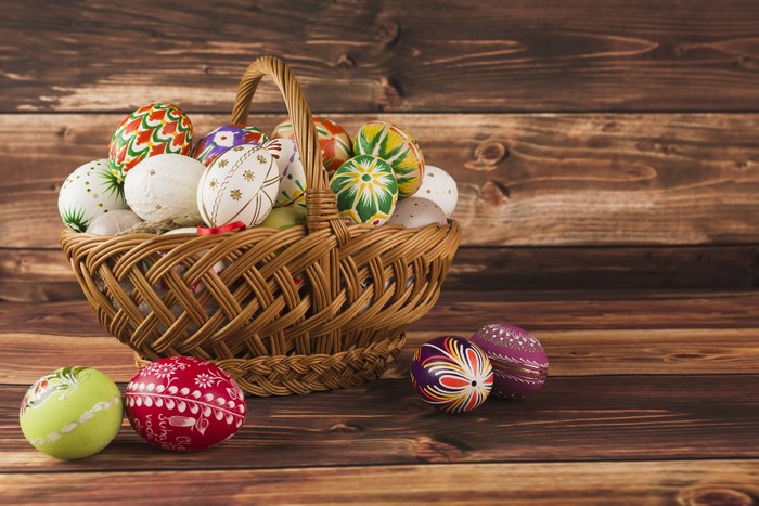 Easter eggs in a wicker basket on wood planks