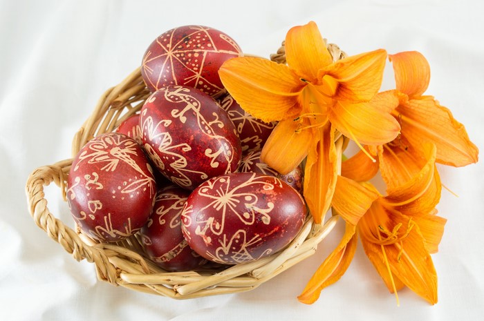 Easter eggs in a wicker basket with lilies