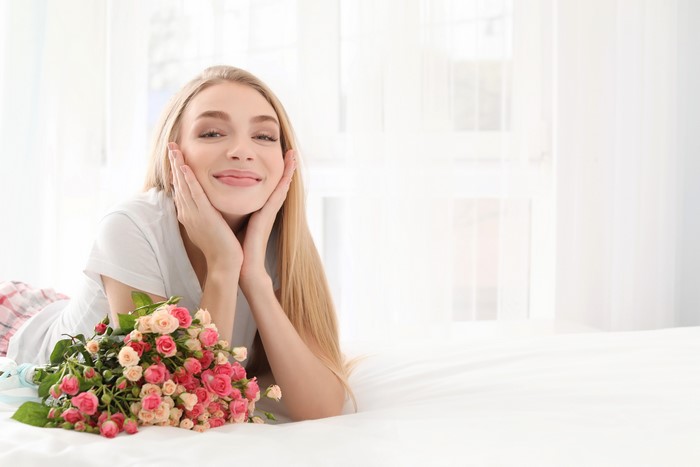 Blonde girl with bouquet of roses smiling