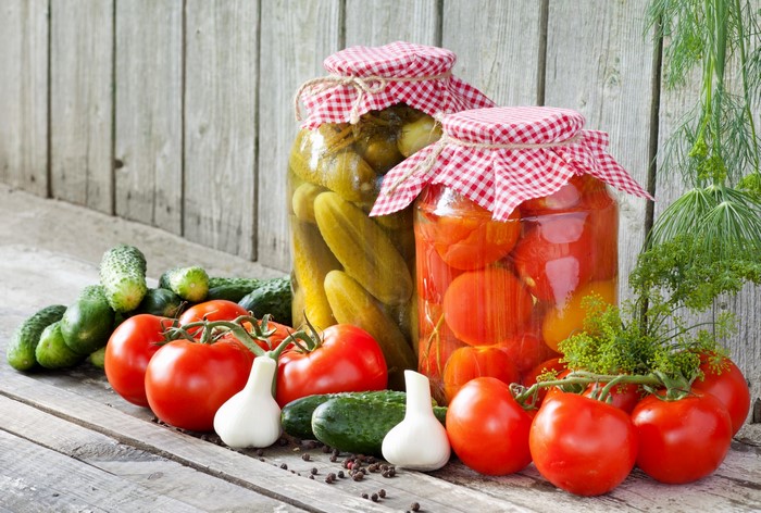 Jars of Pickled Tomatoes and Cucumbers with Fresh Produce