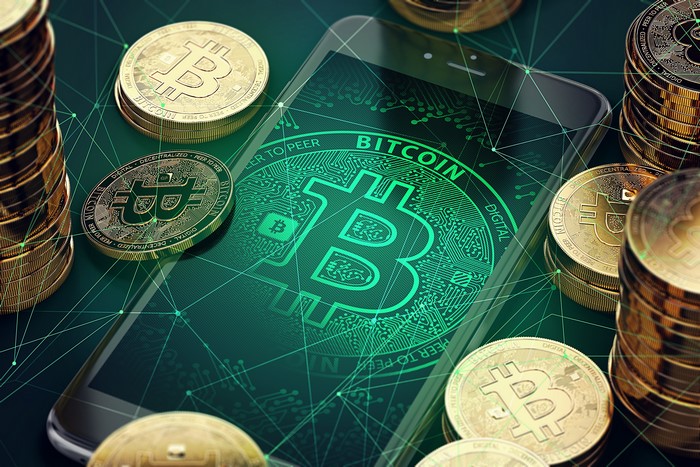 Bitcoin coins and smartphone with Bitcoin logo