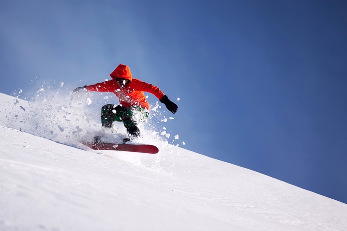 Man snowboarding down a snowy slope