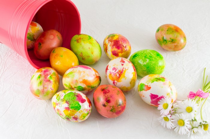 Easter Eggs spilling from a pink bucket with daisies