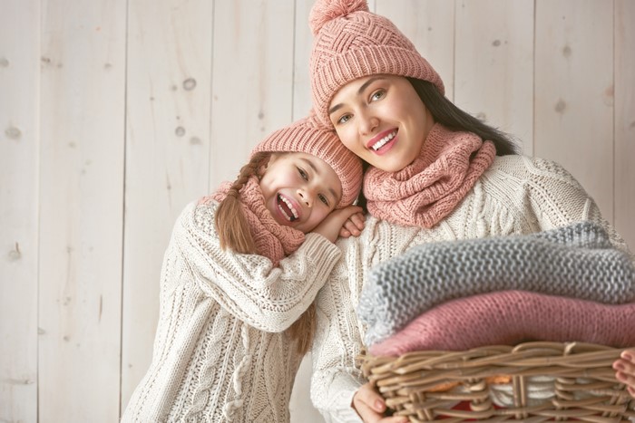 Mother and daughter in winter hats and sweaters