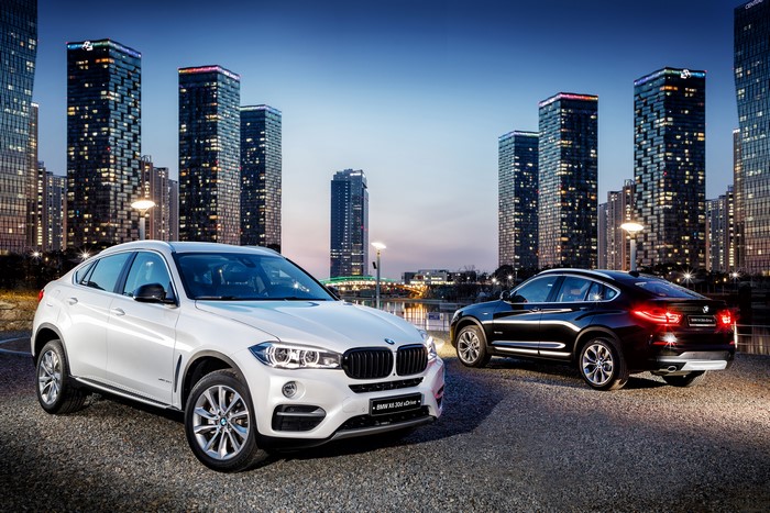 Two BMW X4 cars in a city at dusk