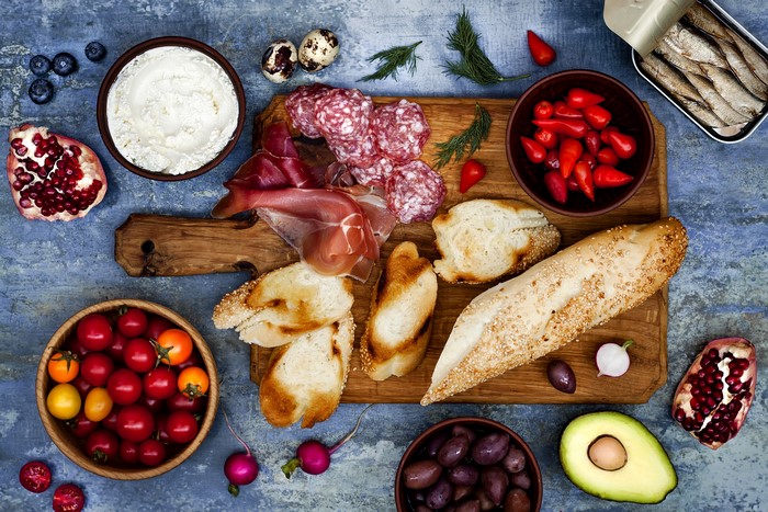 Charcuterie board with bread, cheese, meats, and fruits