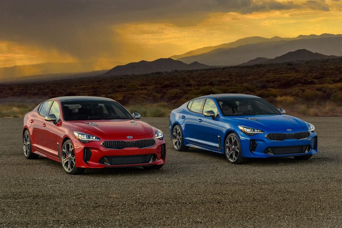 Two Kia Stinger cars in a desert landscape