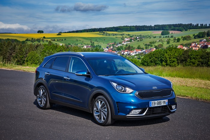 Blue Kia Niro 2016 on a road with countryside background