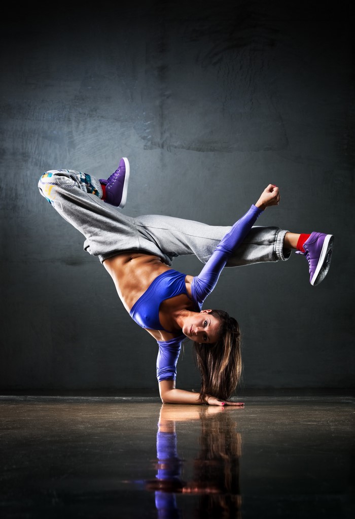 Woman breakdancing on one hand
