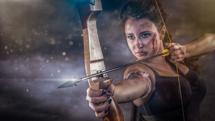 Woman with bow and arrow, battle-worn appearance