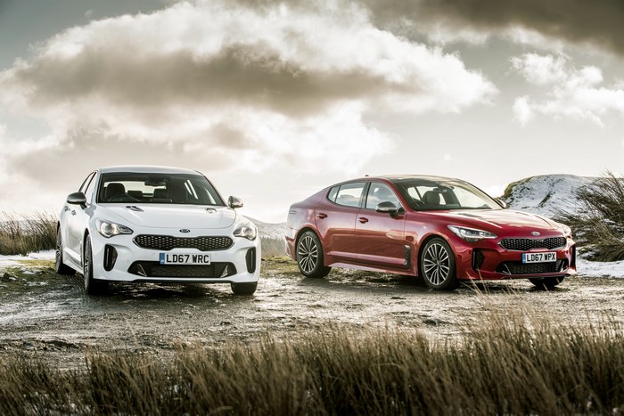 Two Kia Stinger cars in metallic white and red