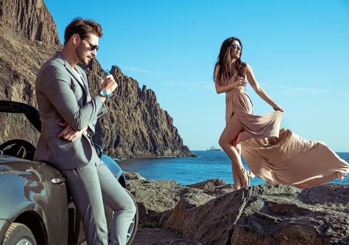 Man in suit and woman in dress by the coast