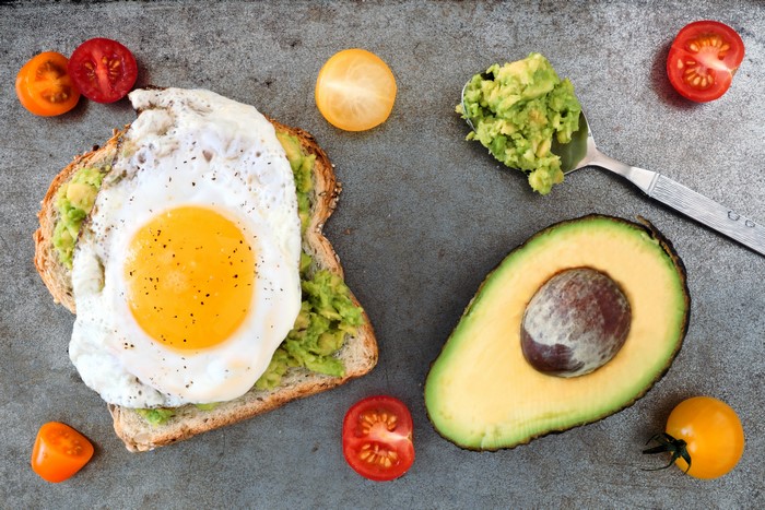 Avocado toast with fried egg and tomatoes