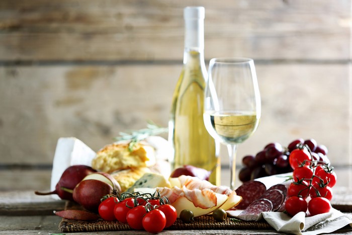 Still-life of wine, cheese, and charcuterie